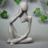 Betonowa figurka rozmarzonego człowieka w odcieniach szarości