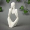 Betonowa figurka rozmarzonego człowieka w odcieniach bieli