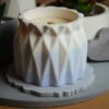 Świeca sojowa Vanilla Flame w betonowym pojemniku w odcieniach bieli i niebieskiego.